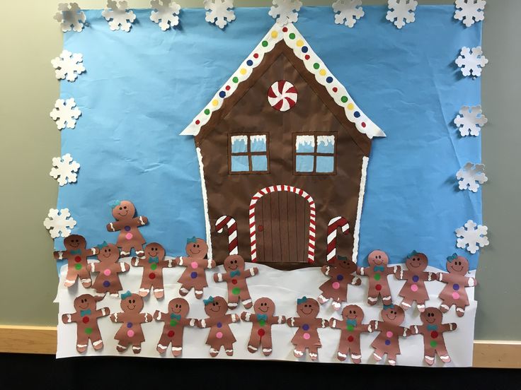 a paper cutout of gingerbread men and women in front of a house