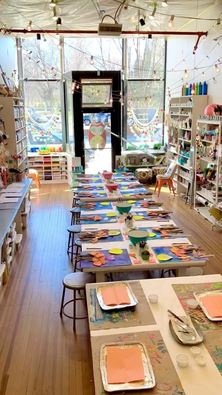 the inside of a craft shop with lots of tables and chairs set up for art work