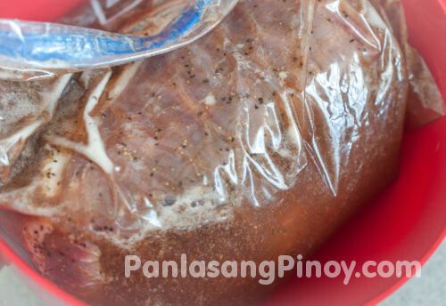 a plastic bag filled with meat sitting on top of a red bowl