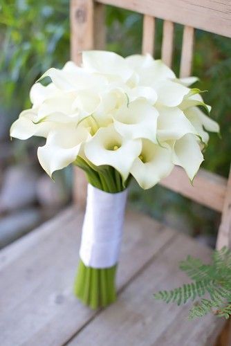 a bouquet of white flowers sitting on top of a wooden chair