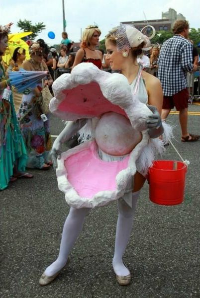 a woman dressed as a bunny holding a bucket and standing in the middle of a street