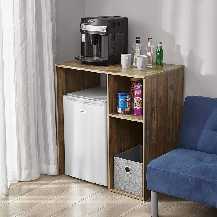 a blue chair sitting next to a small table with a coffee maker on top of it