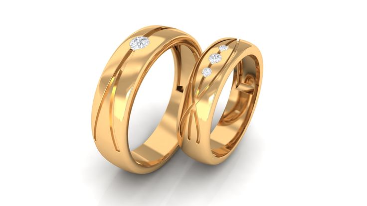 two gold wedding rings with diamonds on each side, set in 18k yellow gold