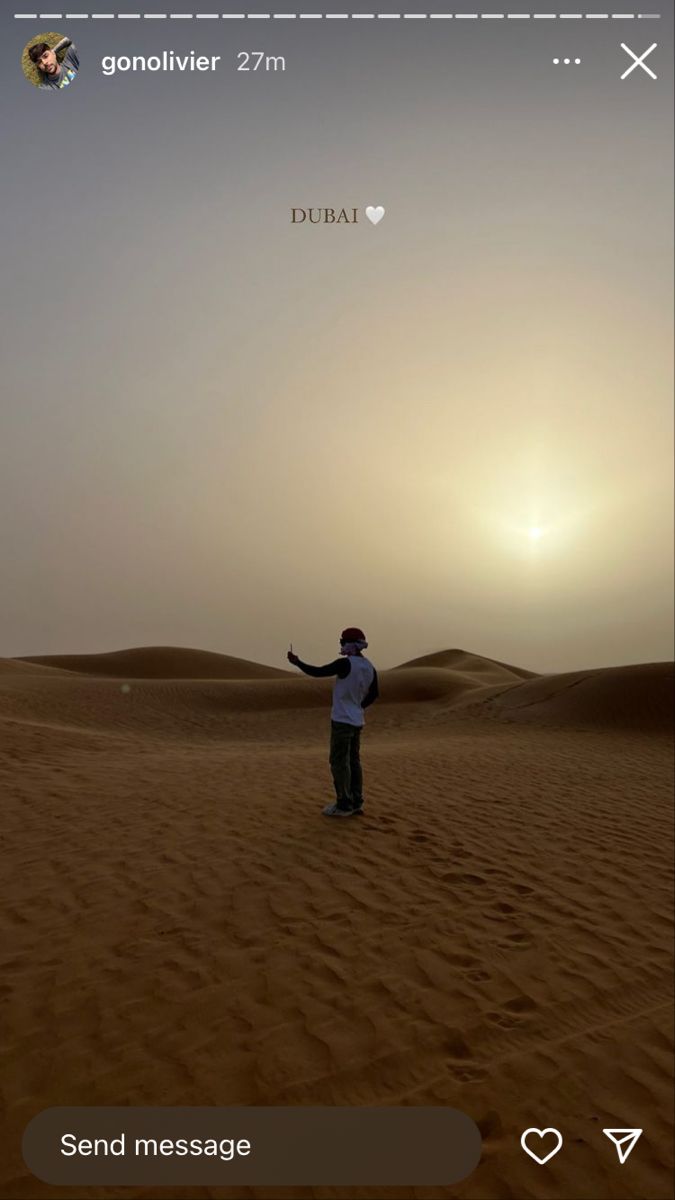 a man standing in the middle of a desert with his arms out to the sun