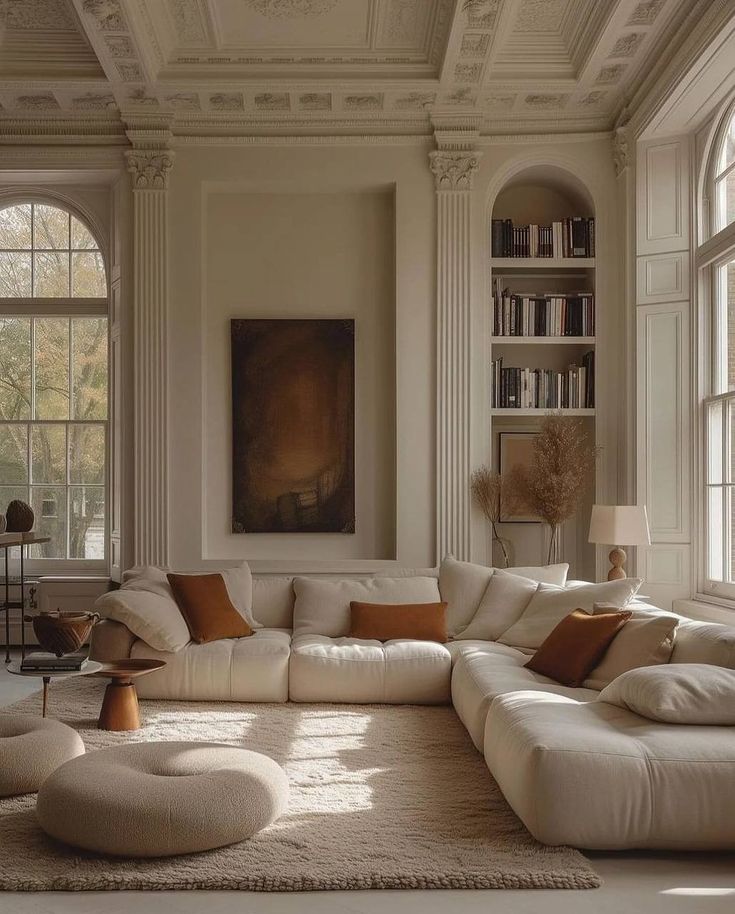 a living room with white couches and large windows