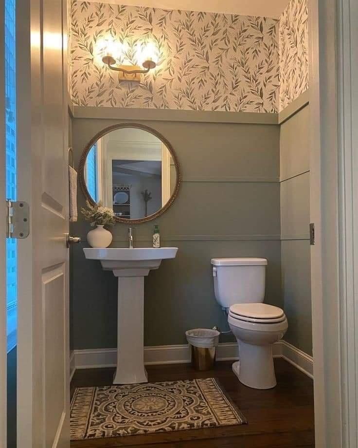 a white toilet sitting next to a bathroom sink under a mirror on top of a wooden floor