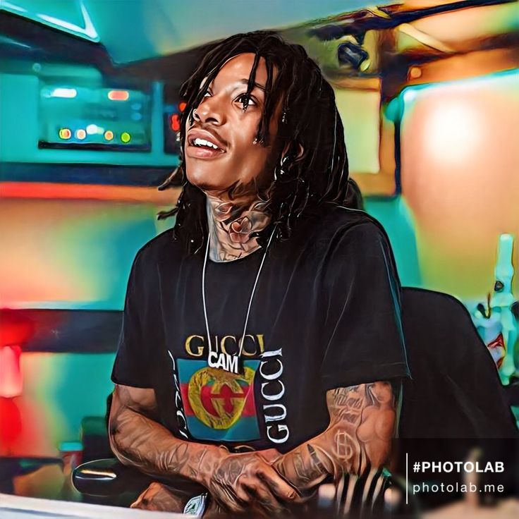 a man with dreadlocks sitting at a desk