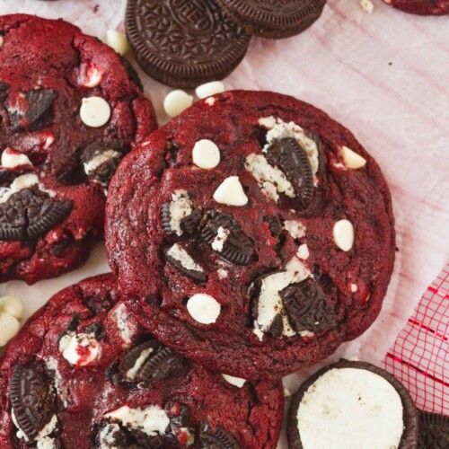 chocolate cookies and oreo cookies on a table with white chocolates in the background