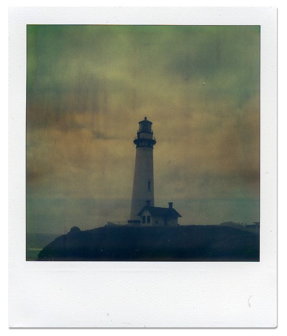 a polaroid photograph of a lighthouse on a cloudy day