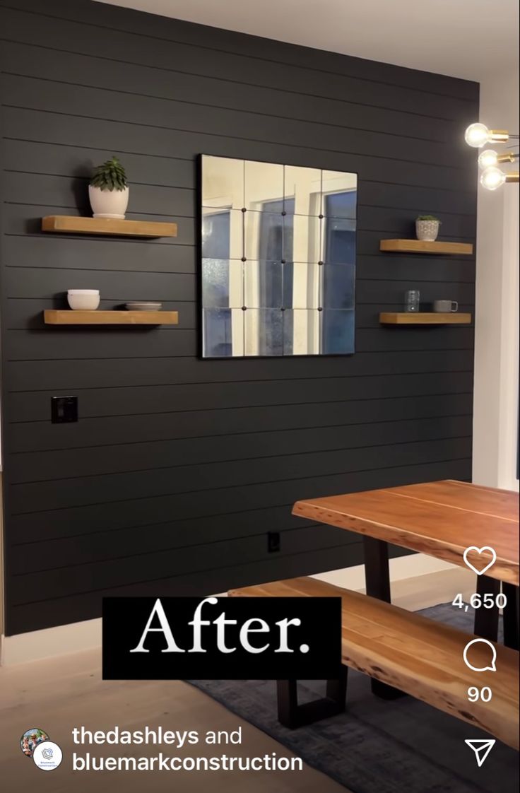 the dining room is painted black and has wooden shelves on either side of the table