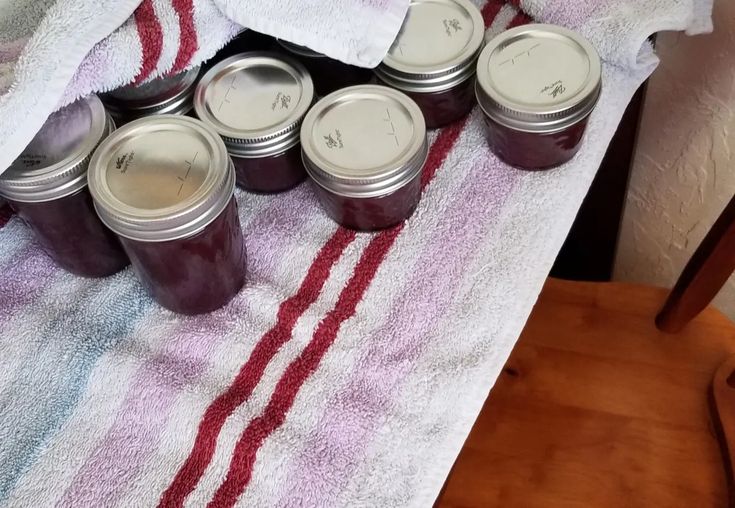 six jars of jam sitting on top of a towel