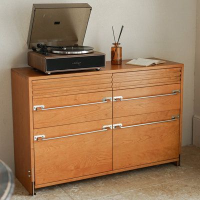 a record player sitting on top of a wooden dresser