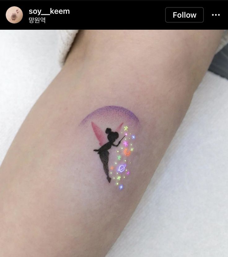 a small tattoo on the arm of a girl with a fairy tale theme and stars