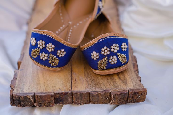 Blue Moon - Royal Blue Ladies' Punjabi Jutti with Zardozi Hand-embroidery Product order for size 6 would take 3-4 weeks to deliver once the order has been placed. When the royal shade of blue meets with some expert intricate hand-work of zardozi, a classic combination of style and convention is established. Style: With some miraculous zardozi and pearl work intricately hand-embroidered on its royal blue Indian crepe fabric base, these jutti shoes are all you need to match with that classic royal Traditional Royal Blue Wear For Reception, Royal Blue Traditional Wear For Reception, Elegant Blue Traditional Wear With Dori Work, Blue Traditional Wear With Gold Embroidery For Festive Season, Blue Traditional Wear With Gota Work For Wedding, Festive Blue Traditional Wear With Gold Embroidery, Elegant Blue Traditional Wear For Ceremonial Occasion, Elegant Blue Traditional Ceremonial Wear, Elegant Blue Ceremonial Traditional Wear