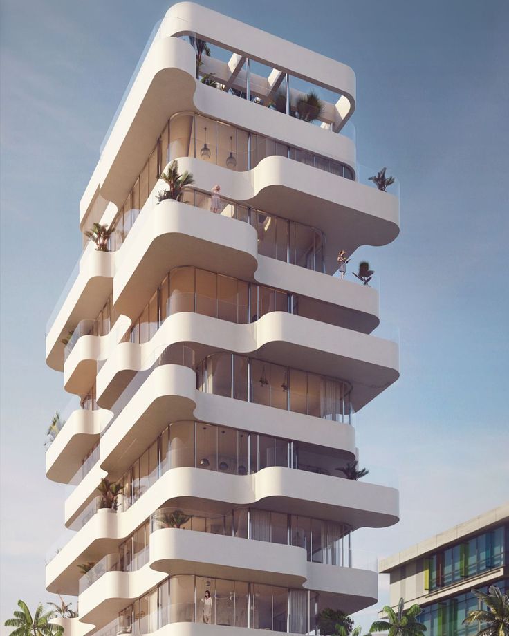 a tall white building with balconies on top