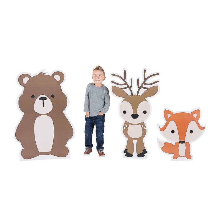 a little boy standing next to some cut outs of animals and bears on a white background