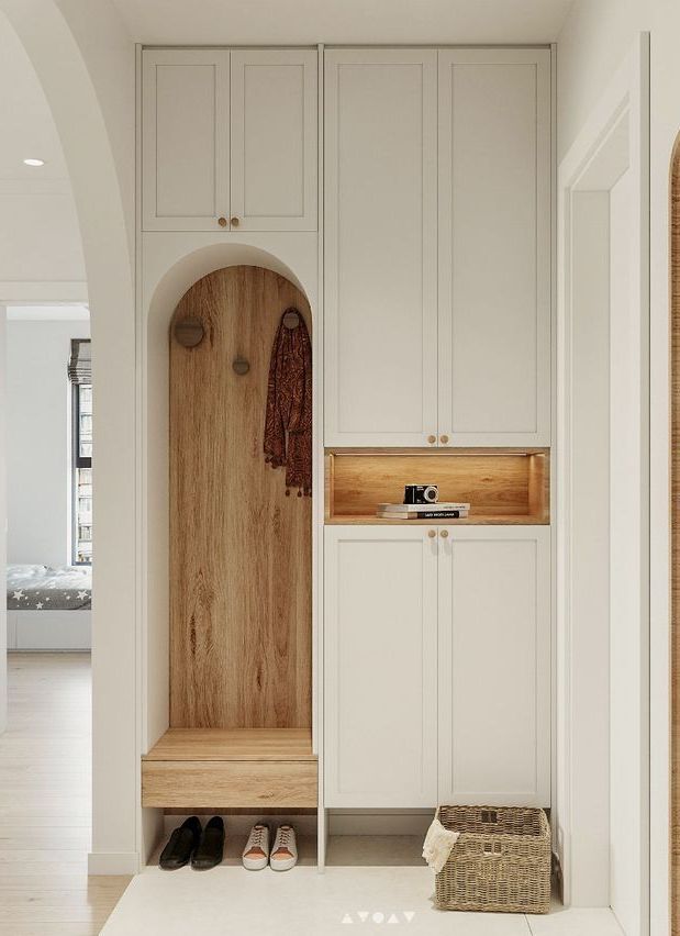 a wooden bench sitting in the middle of a room next to white cupboards and drawers