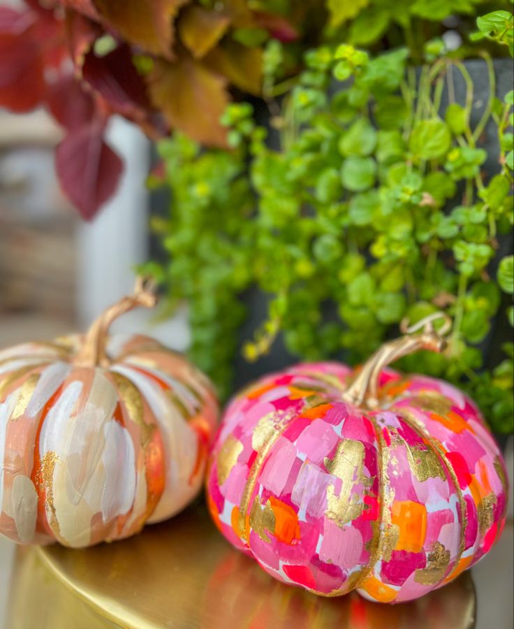 three painted pumpkins sitting on top of a table