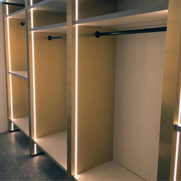 an empty walk - in closet with shelves and lights on the wall, along with no doors