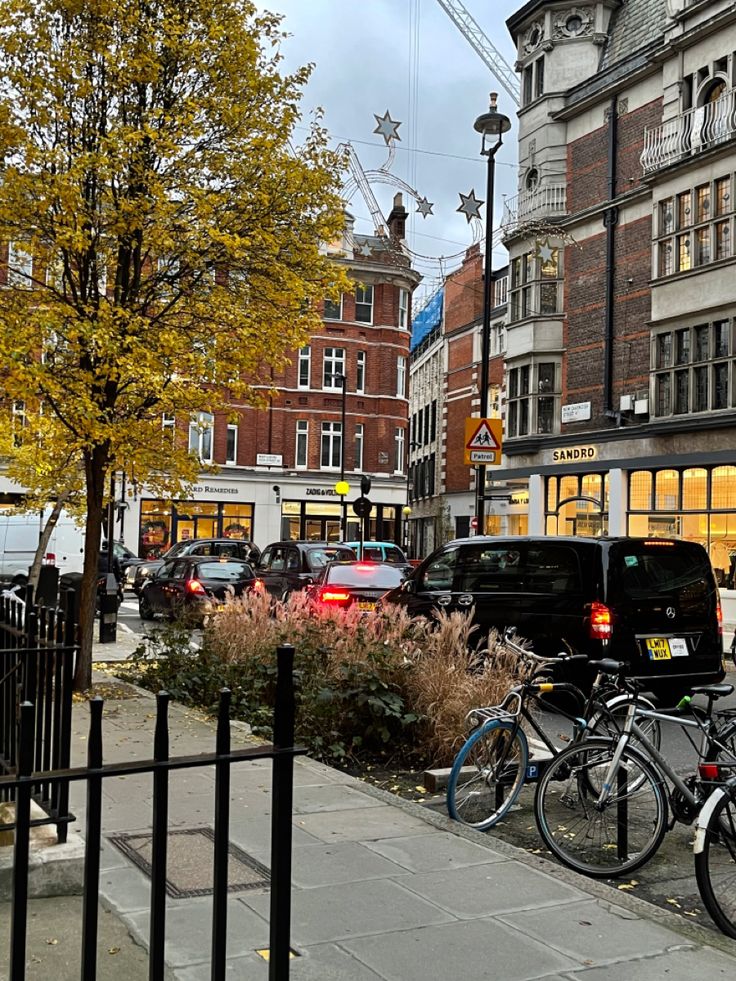 there are many bikes parked on the side of the street in front of some buildings