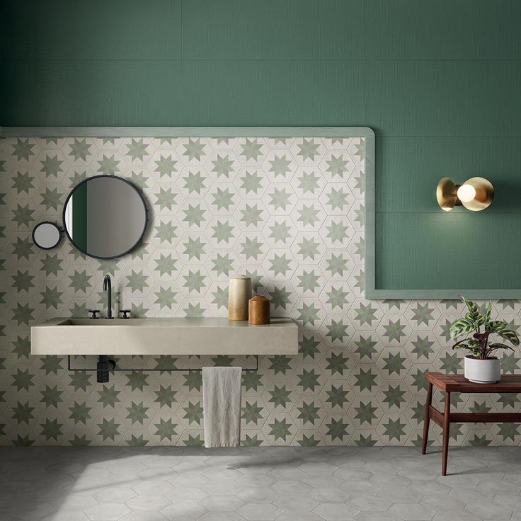 a bathroom with green and white wallpaper, two sinks and a mirror on the wall