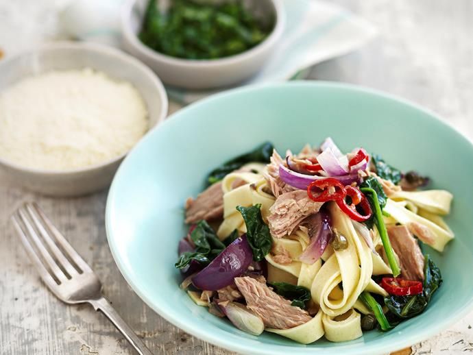 a blue bowl filled with pasta, meat and vegetables