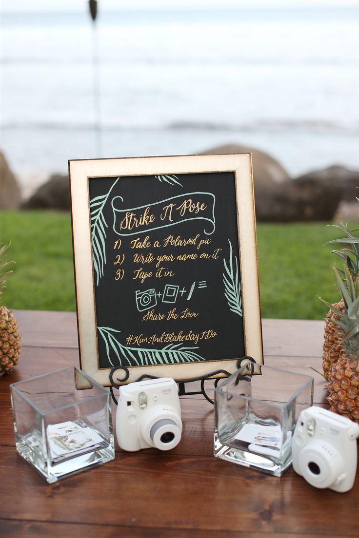 pineapples and cameras are sitting on a table with a chalkboard sign in the background