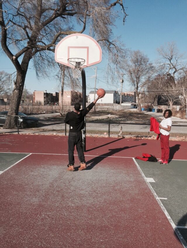 two people playing basketball on an outdoor court