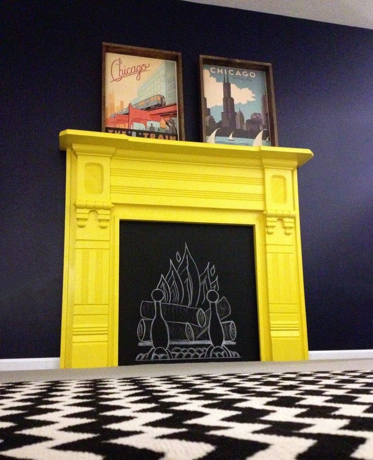 a black and white checkered floor in front of a yellow fireplace with two pictures above it