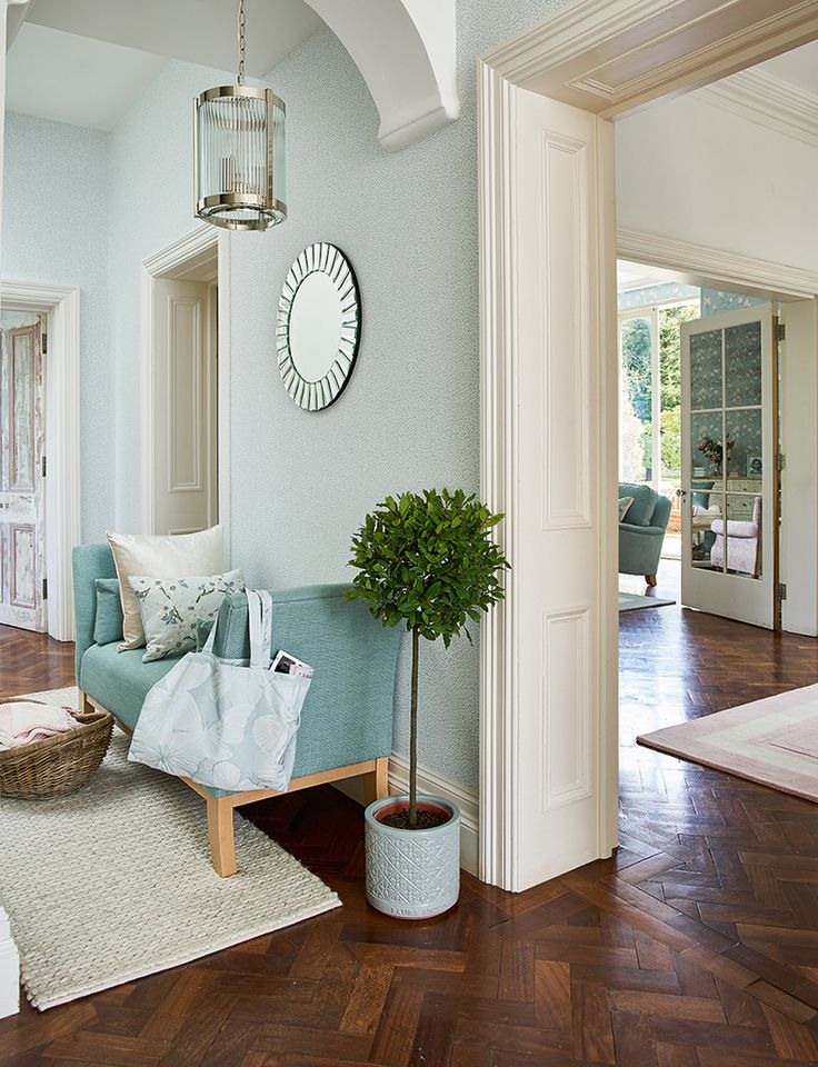 a living room with blue couches and pillows on the floor in front of a mirror