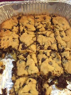 a baking pan filled with cookies and chocolate chip bars on top of aluminum foil covered in tinfoil