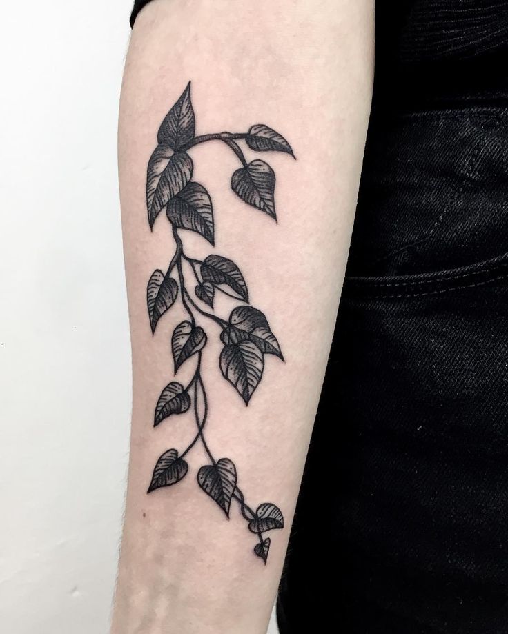 a woman's arm with leaves on it