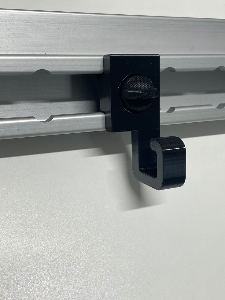 a close up of a metal door handle on a white refrigerator with black latches