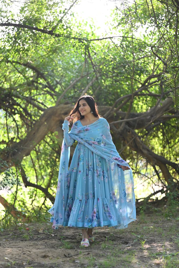 PRODUCT DESCRIPTION :-Presenting Sky floral Printed chiffon tiered pattern Anarkali with matching Chiffon dupatta and cotton Pants . The flare of the Anarkali and Most comfortable fit will fill your heart with Immense Joy . Anarkali :- Chiffon Pant :- CottonDupatta :- ChiffonClosure Used:- Side zipColor:- SkyCare Instructions :- Dry clean onlyModel Size :- Model is wearing XS sizeModel Height :- 5.6''DISCLAIMER :- Slight color variations may occur due to different screen resolution. Diwali Georgette Anarkali Set With Ruffles, Diwali Ruffled Georgette Anarkali Set, Ruffled Georgette Anarkali Set For Diwali, Eid Anarkali Set With Ruffles, Blue Anarkali Sharara With Ruffles, Anarkali Georgette Palazzo Set With Ruffles, Bohemian Georgette Anarkali Set For Diwali, Bohemian Floor-length Sharara With Sheer Dupatta, Bohemian Anarkali Set With Dupatta Maxi Length