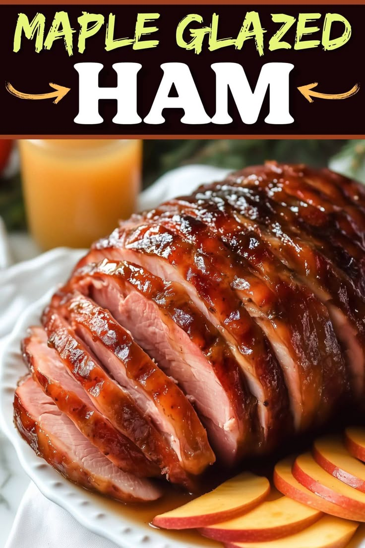 sliced ham on a white plate with apples and orange juice next to the words maple glazed ham