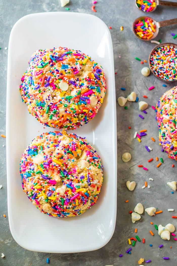 three sprinkled donuts on a white plate