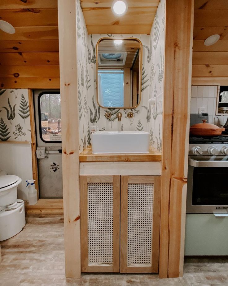 a bathroom with a sink, mirror and toilet in it's stall next to a window