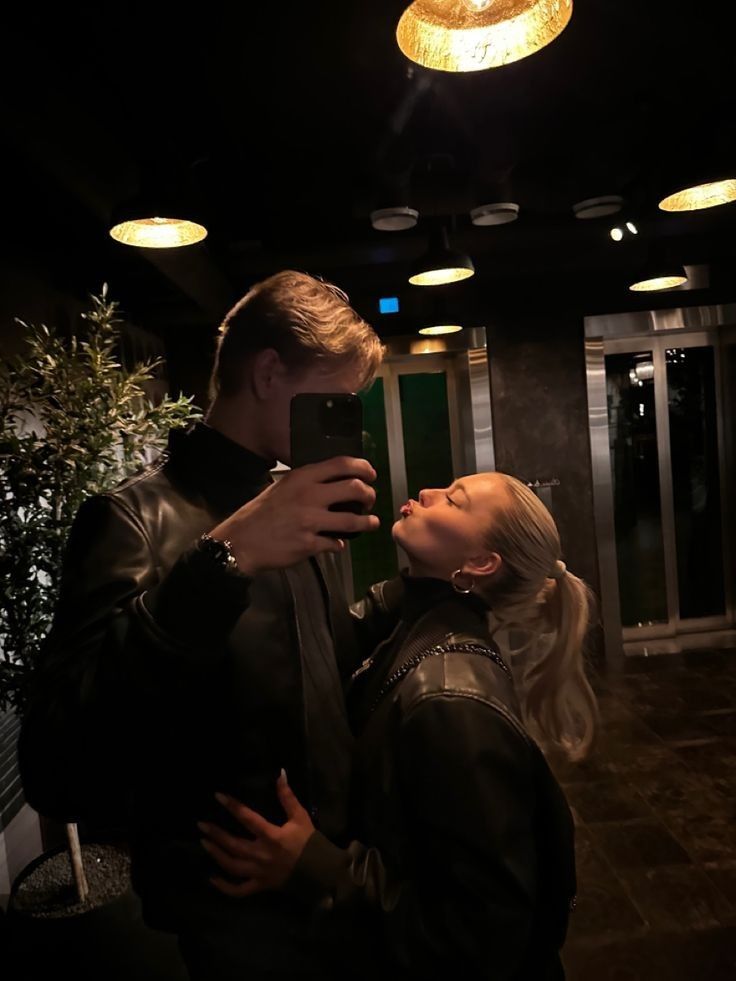 a man and woman taking a selfie in the dark