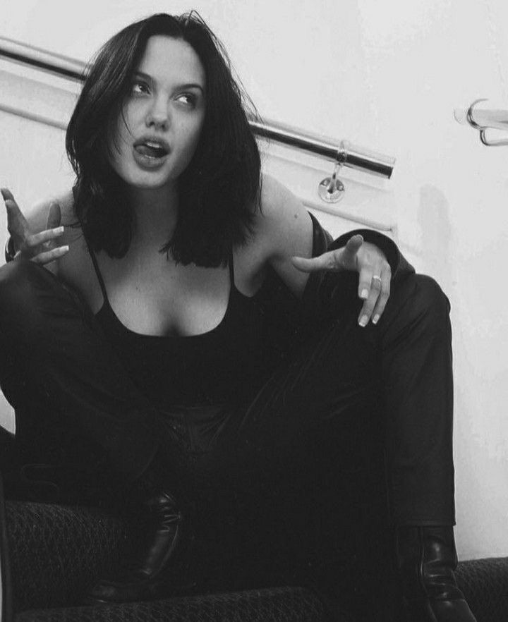 black and white photograph of a woman sitting on the toilet