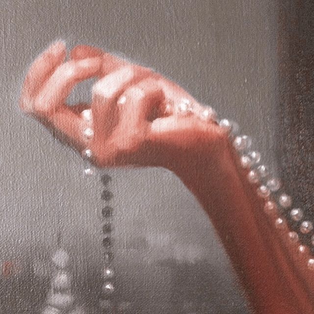 a close up of a person's hand with pearls on it