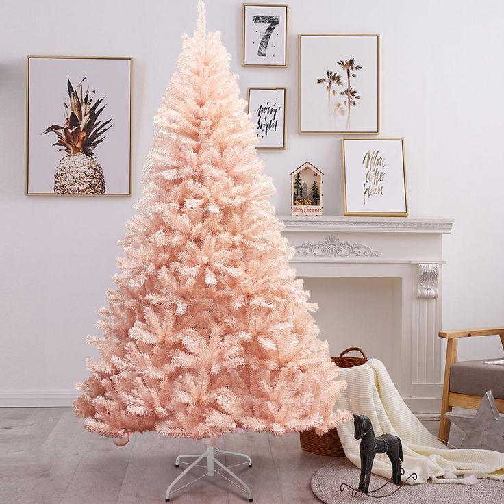 a pink artificial christmas tree sitting on top of a wooden floor next to a fireplace