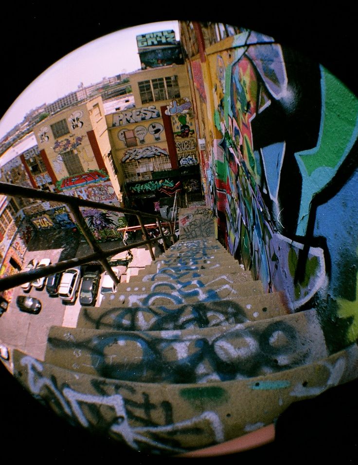 an image of graffiti on the side of a building with stairs and railings in front of it