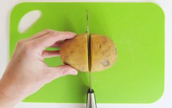 a person cutting up a potato on a green cutting board with a pair of scissors