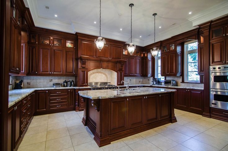 a large kitchen with wooden cabinets and marble counter tops