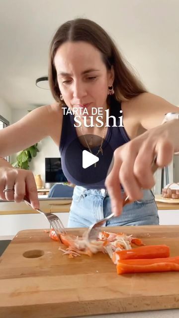 a woman cutting up carrots on top of a wooden cutting board with a knife and fork