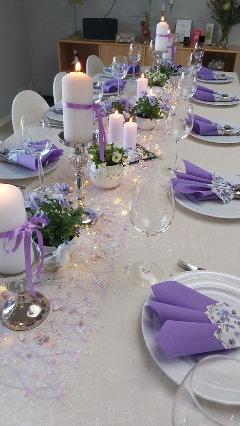 the table is set with purple and white decorations