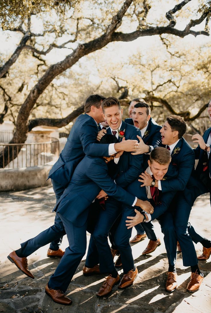 Groomsmen wearing blue suits on wedding day having fun with groom outside in sunshine Cute Groomsmen Pictures, Groomsmen Poses With Groom, Wedding Pics Groomsmen, Navy Tux Fall Wedding, Wedding Photography Action Shots, Wedding Photo Inspiration First Look, Wedding Day Photo Ideas Groomsmen, Wedding Photo Inspiration Groomsmen, Wedding Photo With Wedding Party