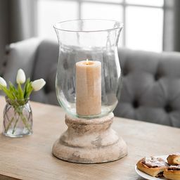 a candle sits on a table next to some cookies and a vase with flowers in it