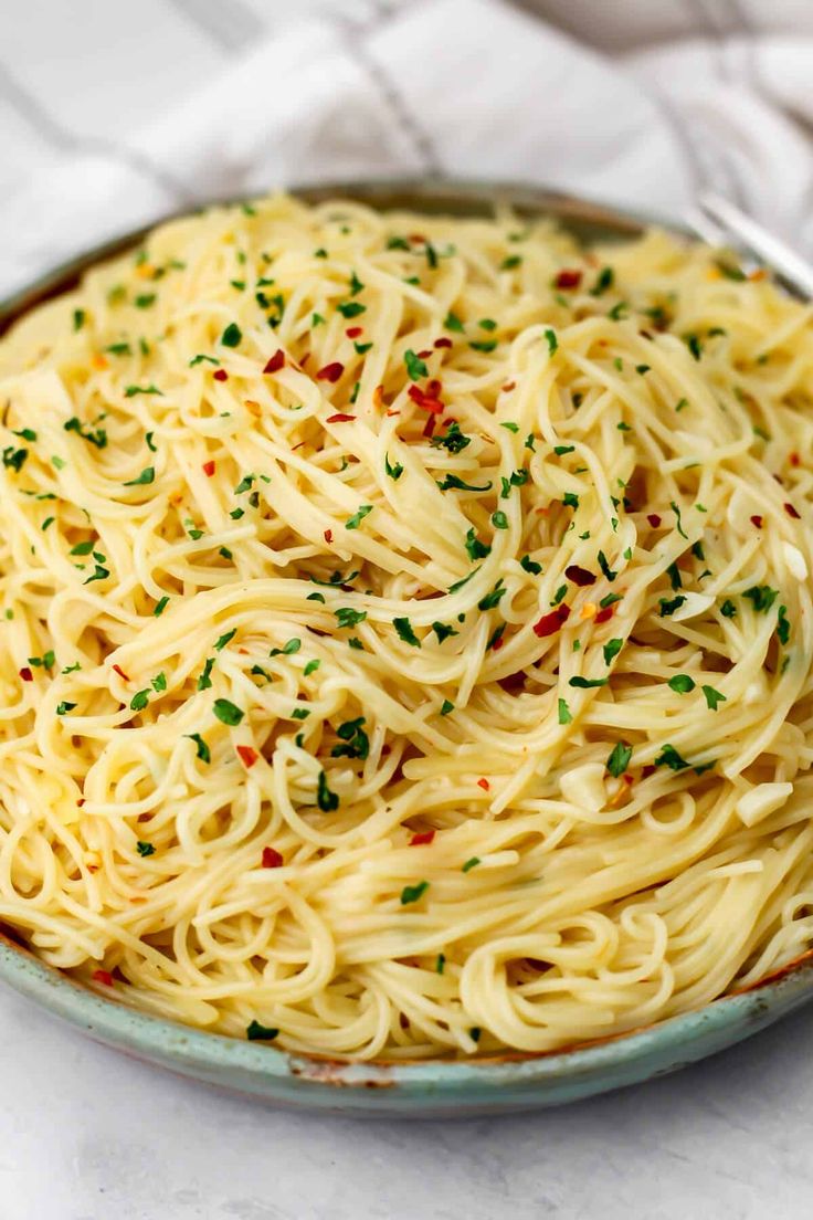 a plate full of pasta with parsley sprinkled on the top and bottom