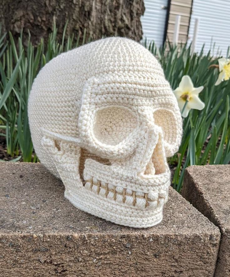 a crocheted skull sitting on top of a cement block